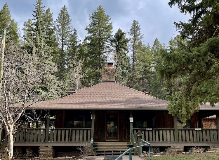 old 1-story cabin with wrap-around porch and center chimney