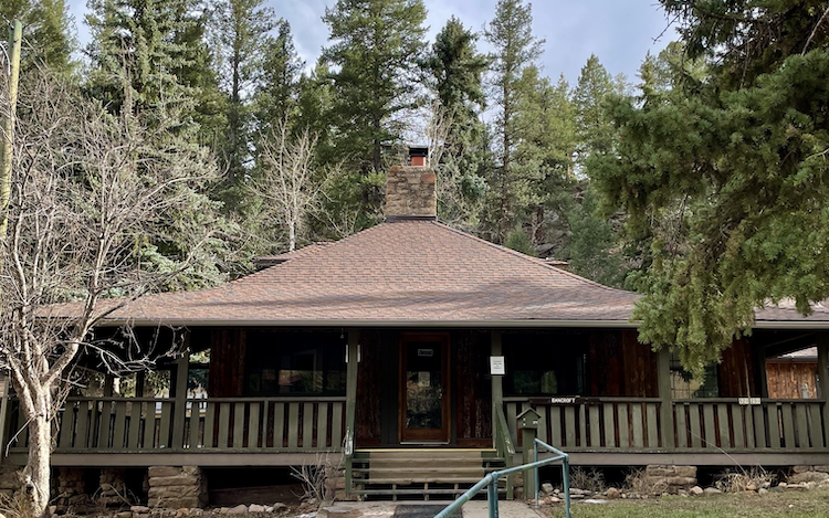 old 1-story cabin with wrap-around porch and center chimney