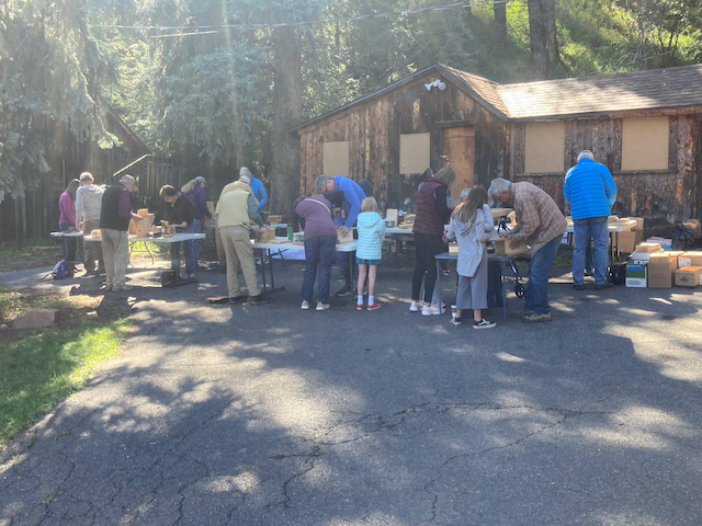 people standing around tables building birdboxes