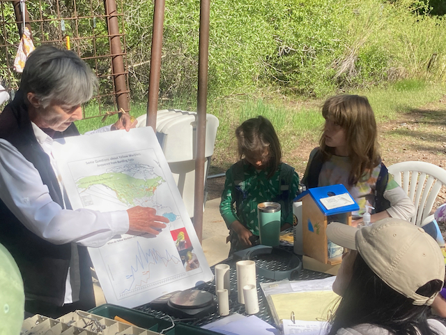 Bird Bander showing a large poster to several children