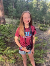 young girl outside with binoculars around her neck